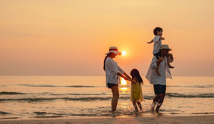 family on beach during sunset