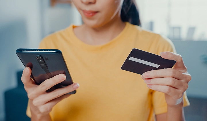 woman on phone with a debit card